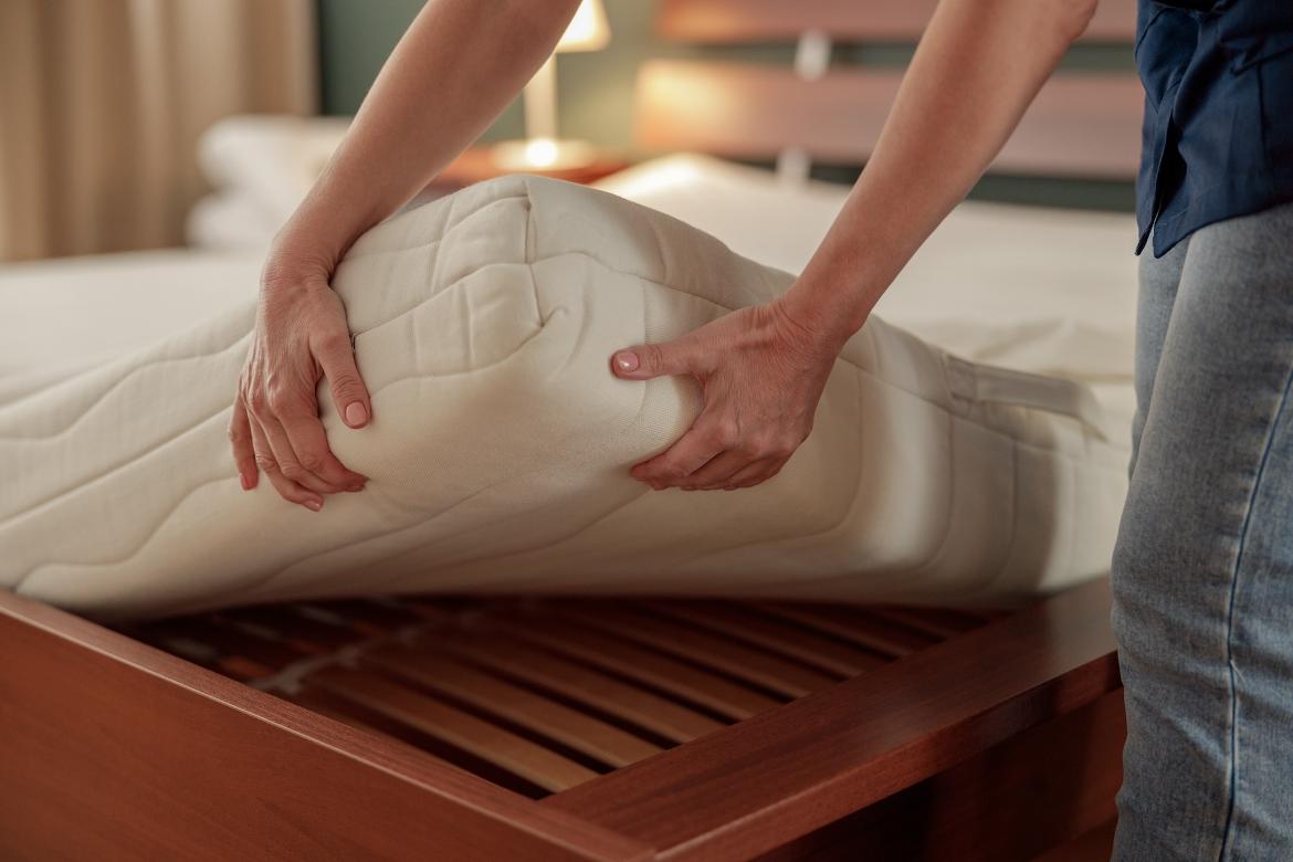 a woman lifting a mattress